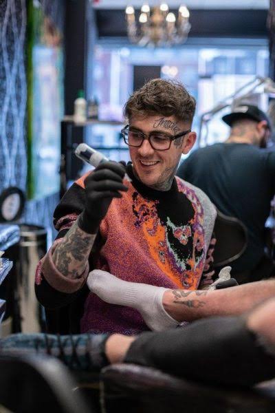 Tattoo studio shopfront with bold hand-lettered window signage