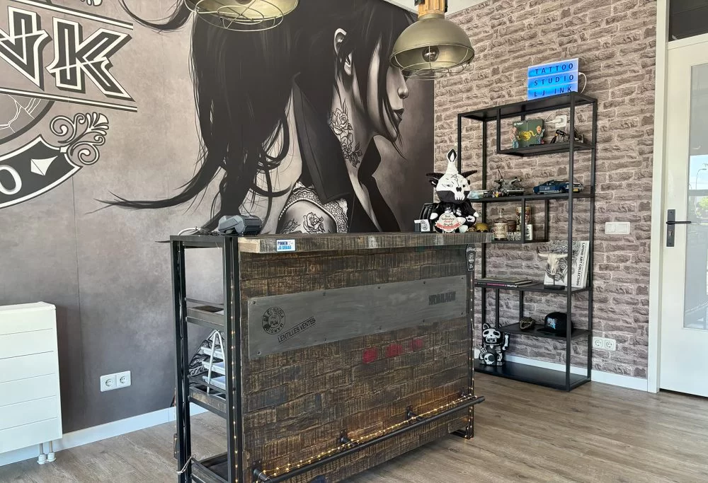 Warm, flower-draped tattoo studio with Edison bulbs