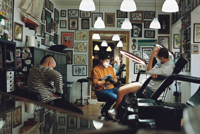 Amber-lit tattoo studio with hanging pendant lights